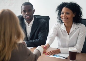 two women shaking hands in a business meeting